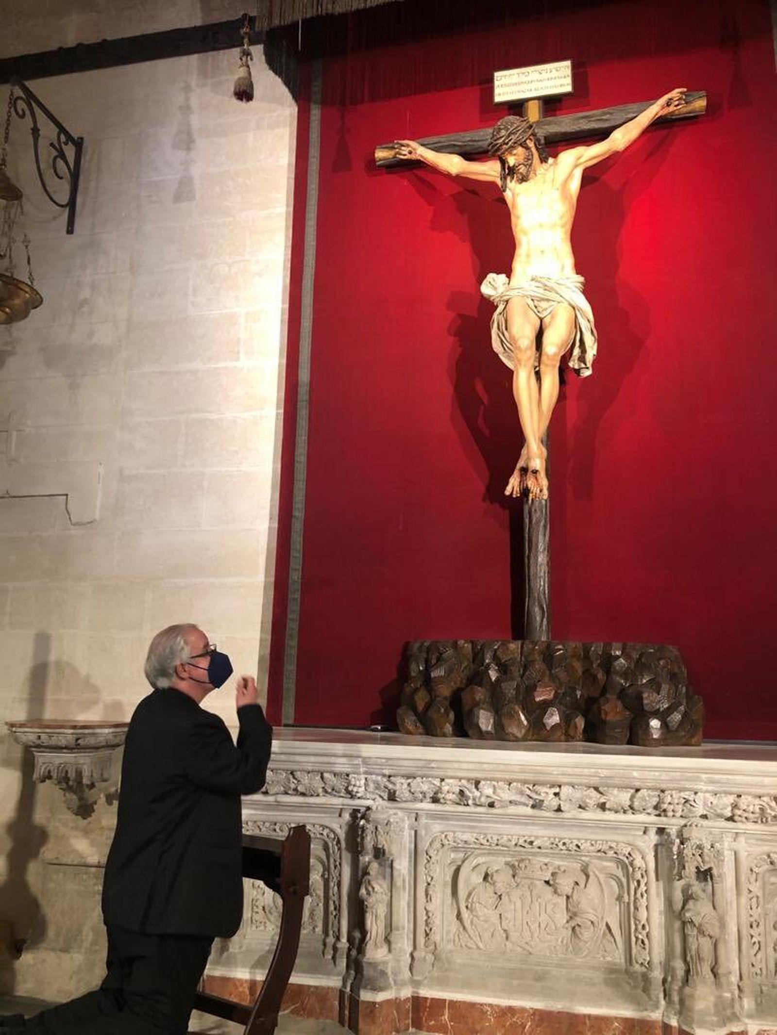 Monseñor Saiz reza ante el Cristo de la Clemencia.