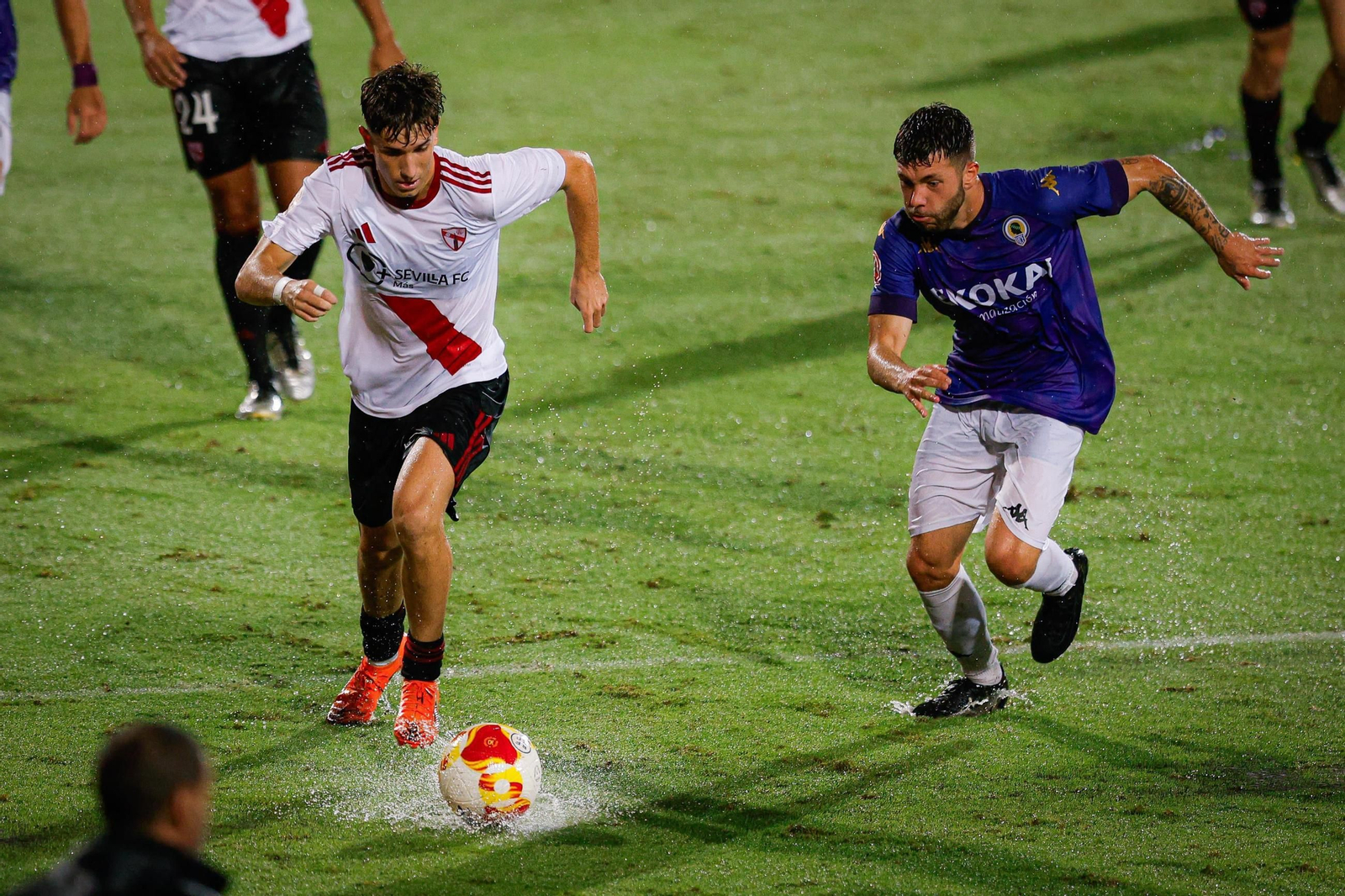 Collado intenta un avance con el césped encharcado tras el chaparrón.