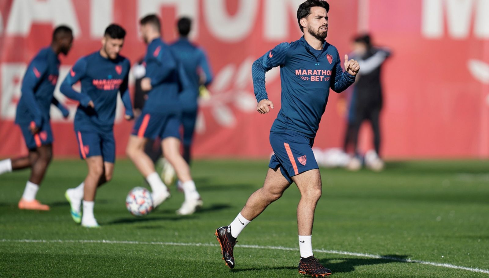 Suso, con Óscar al fondo, durante el entrenamiento del Sevilla de este domingo.