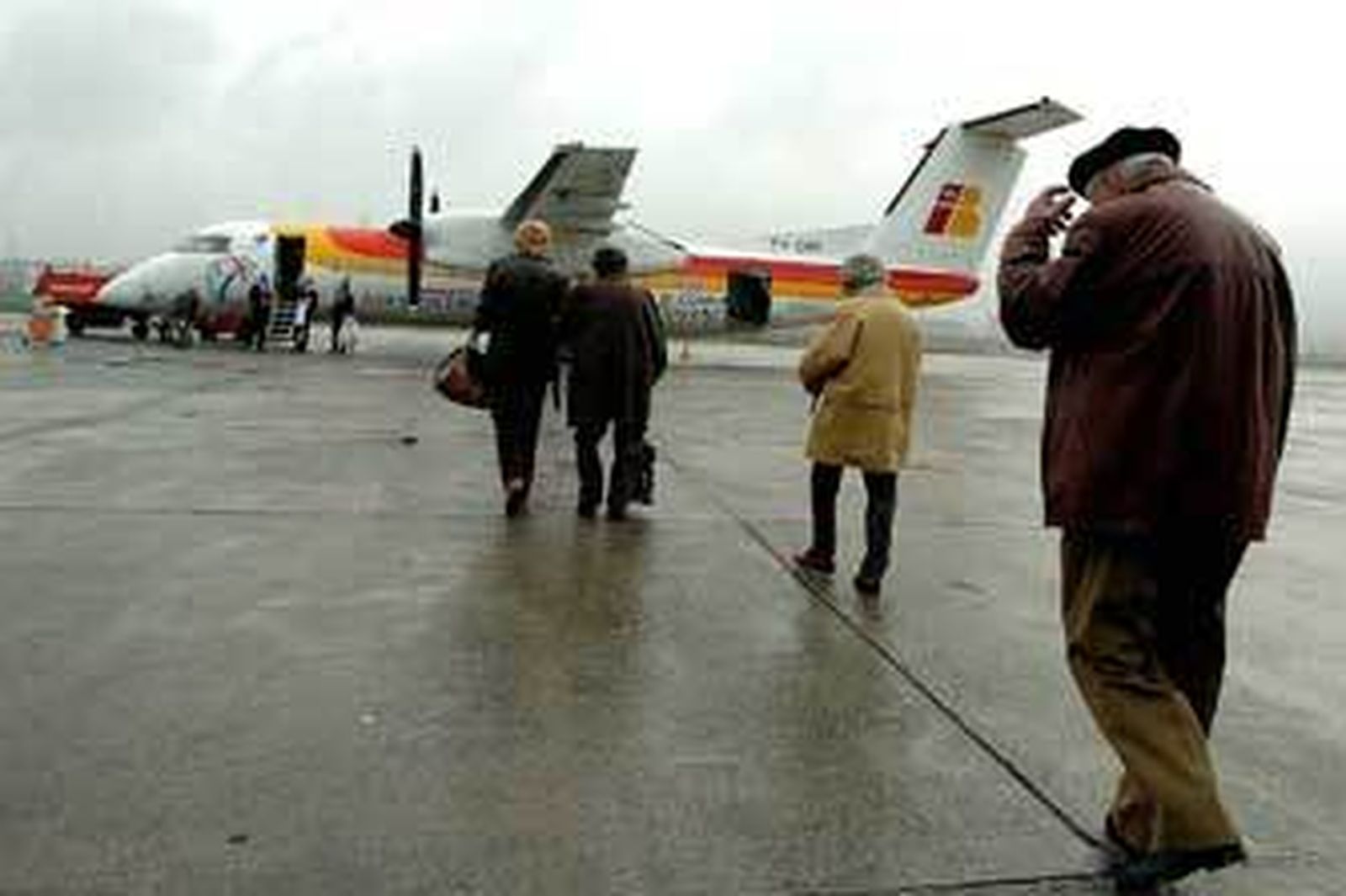 Pasajeros acceden a un avión de Air Nostrum un día de lluvia. /Juan Herrero