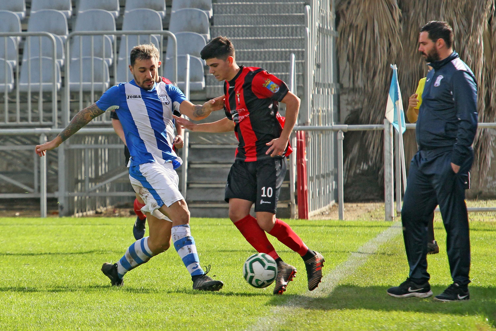 Juanjo Durán observa en la banda el intento de corte de Dani Castro ante un jugador del Chiclana Industrial.