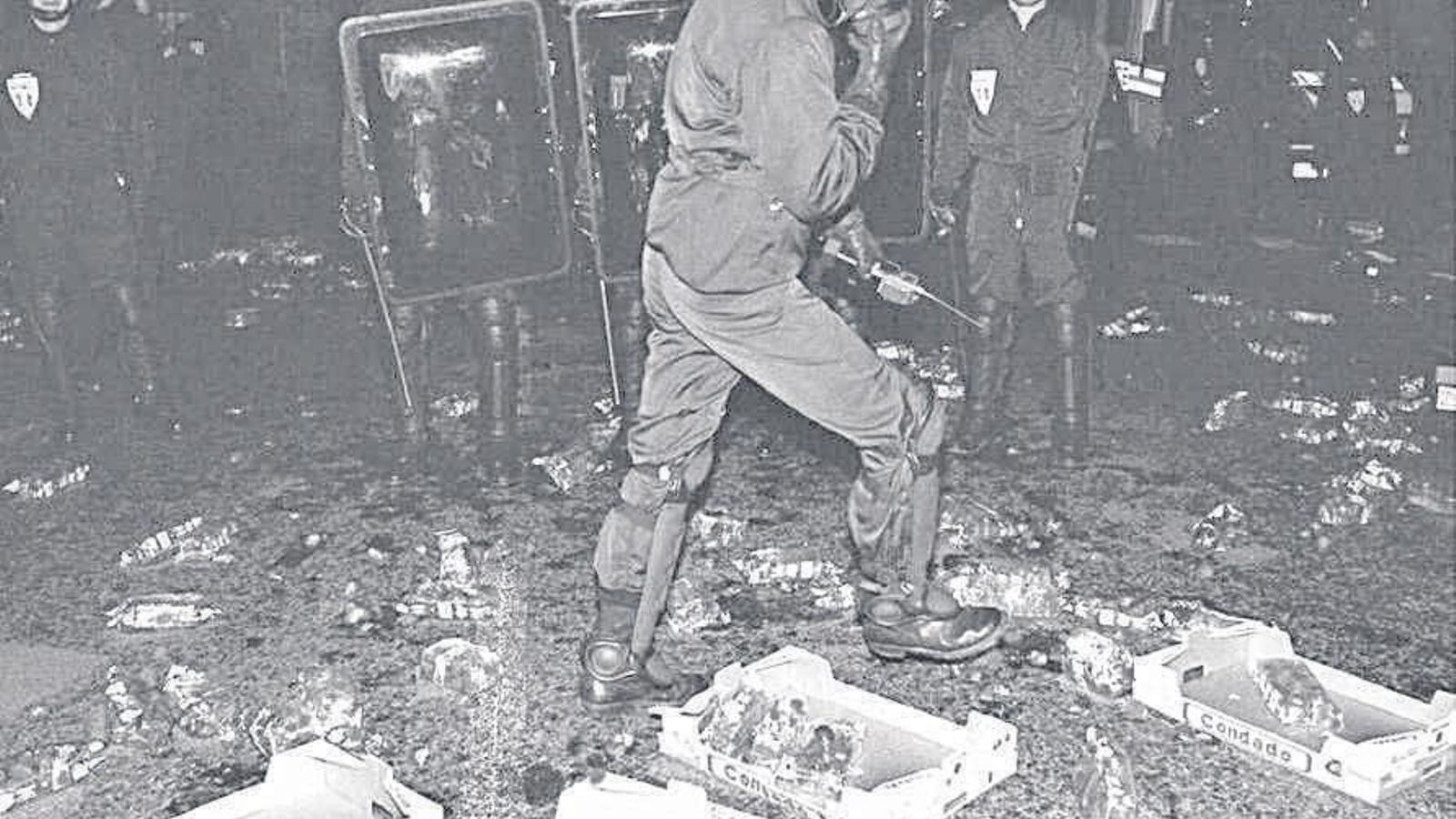 Un policía camina  entre las fresas  tiradas por  los campesinos  galos en  abril de 1998.