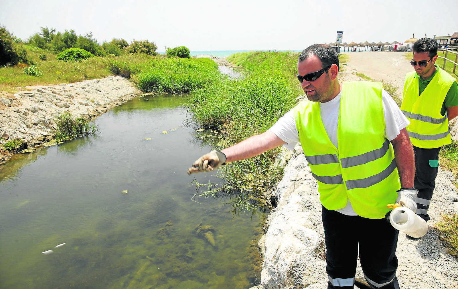 Dos técnicos de Athisa examinan uno de los canales de pluviales del río Guadalhorce.
