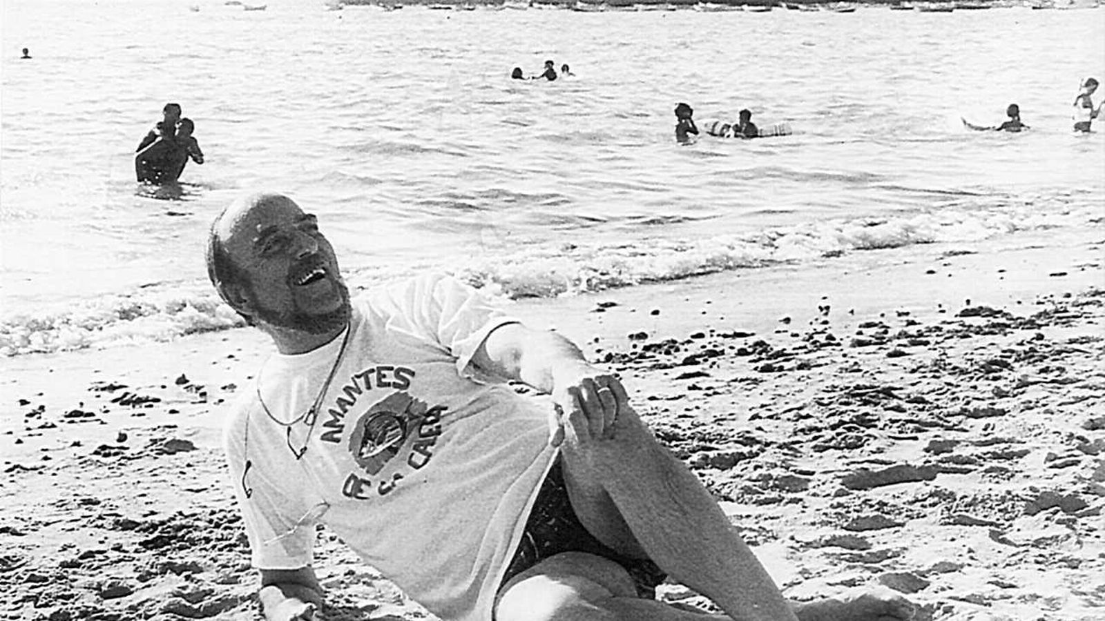 El escritor Fernando Quiñones, amante de La Caleta, como reza en la camiseta que luce junto a la orilla.