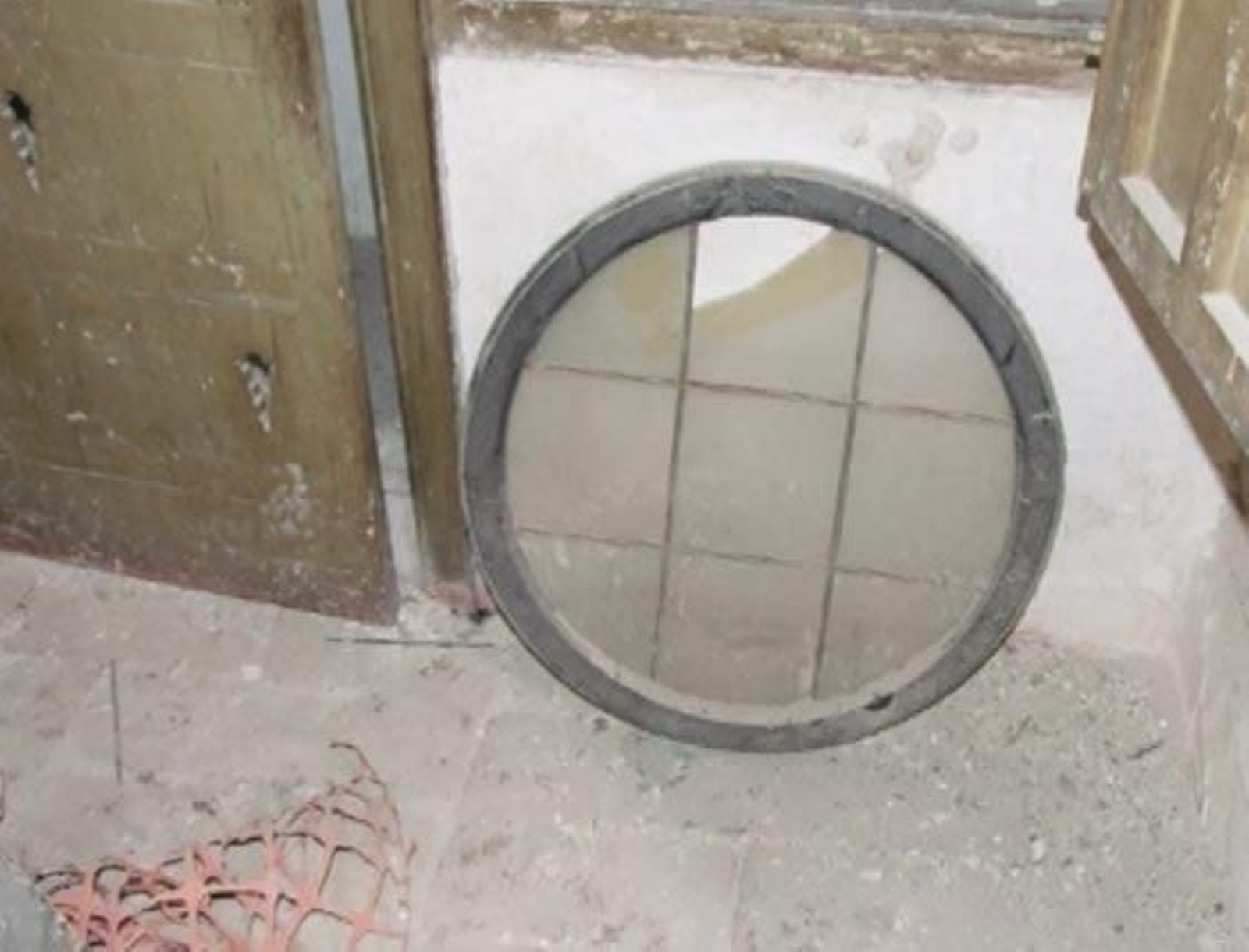 Cristal de un ventanal roto en el suelo, junto a más escombros.