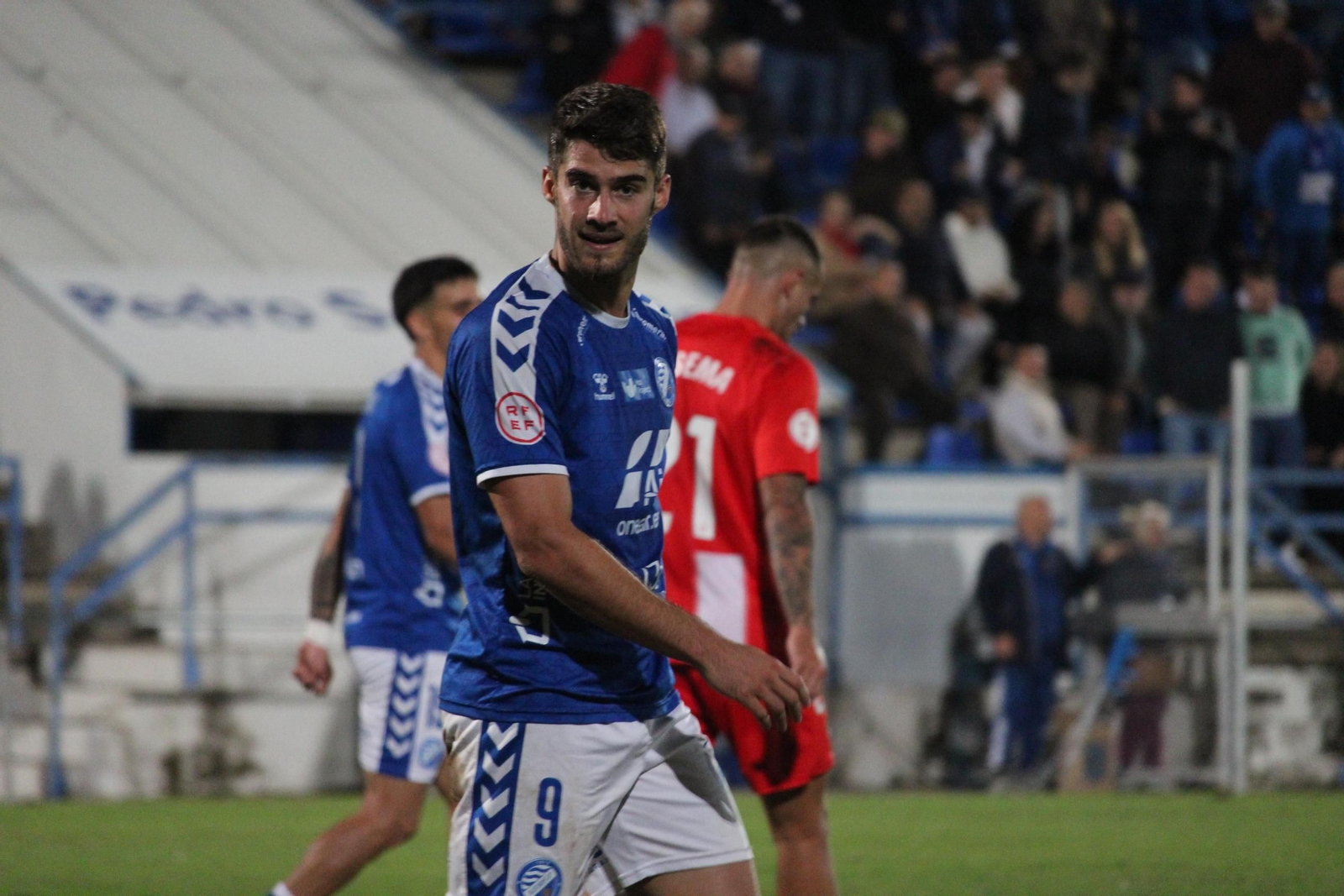 Un jugador azulino se lamenta de una ocasión del partido con el rojiblanco Josema de espaldas.