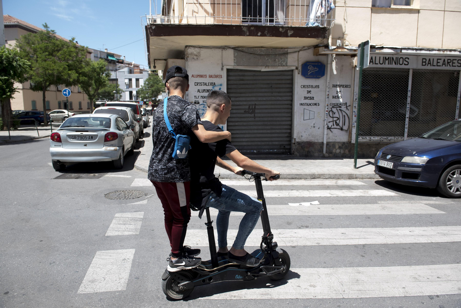 Dos jóvenes en un patinete eléctrico por el Zaidín
