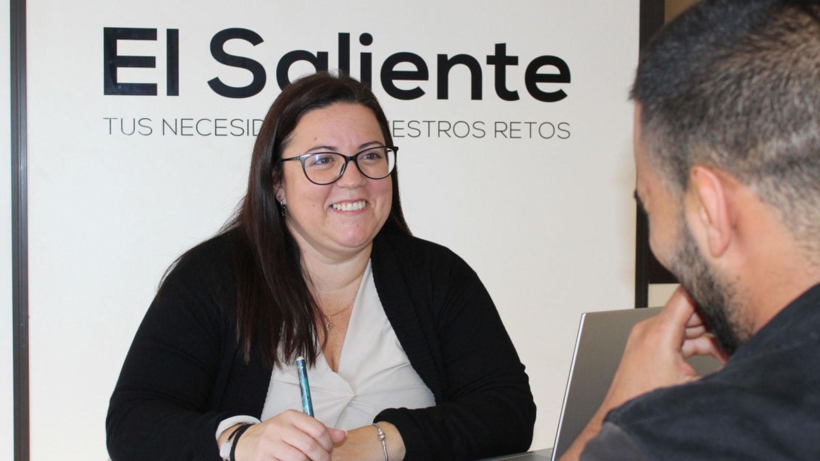 Una de las trabajadoras de la asociación El Saliente atiende a un usuario