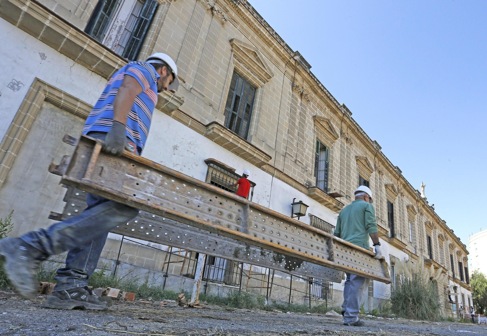 Trabajadores encargados de tapiar los accesos de la antigua bodega Díez Mérito, junto a la plaza de la Estación.