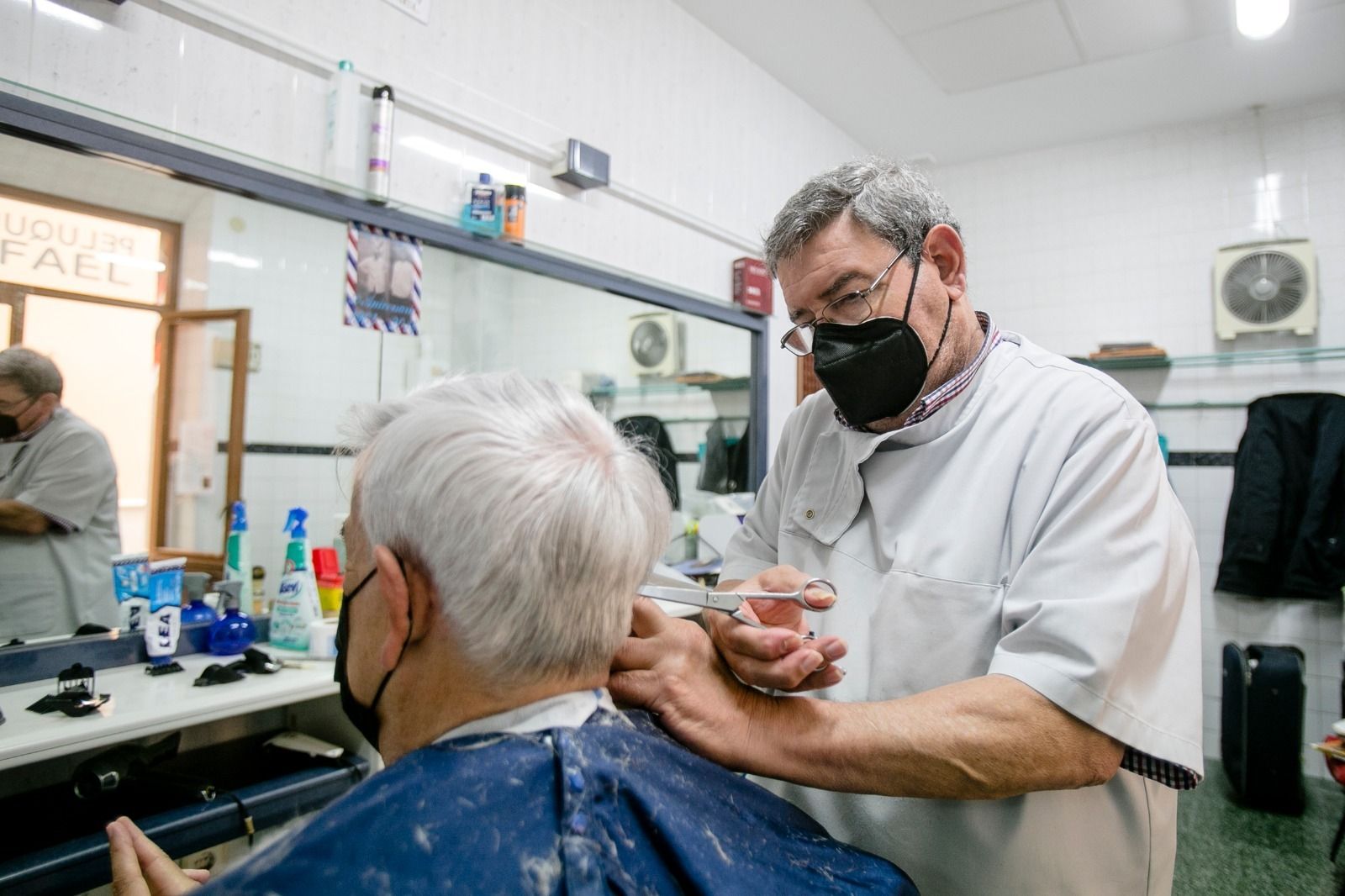 José María García López, de Peluquería Rafael, con uno de sus clientes, Joaquín Fernández.