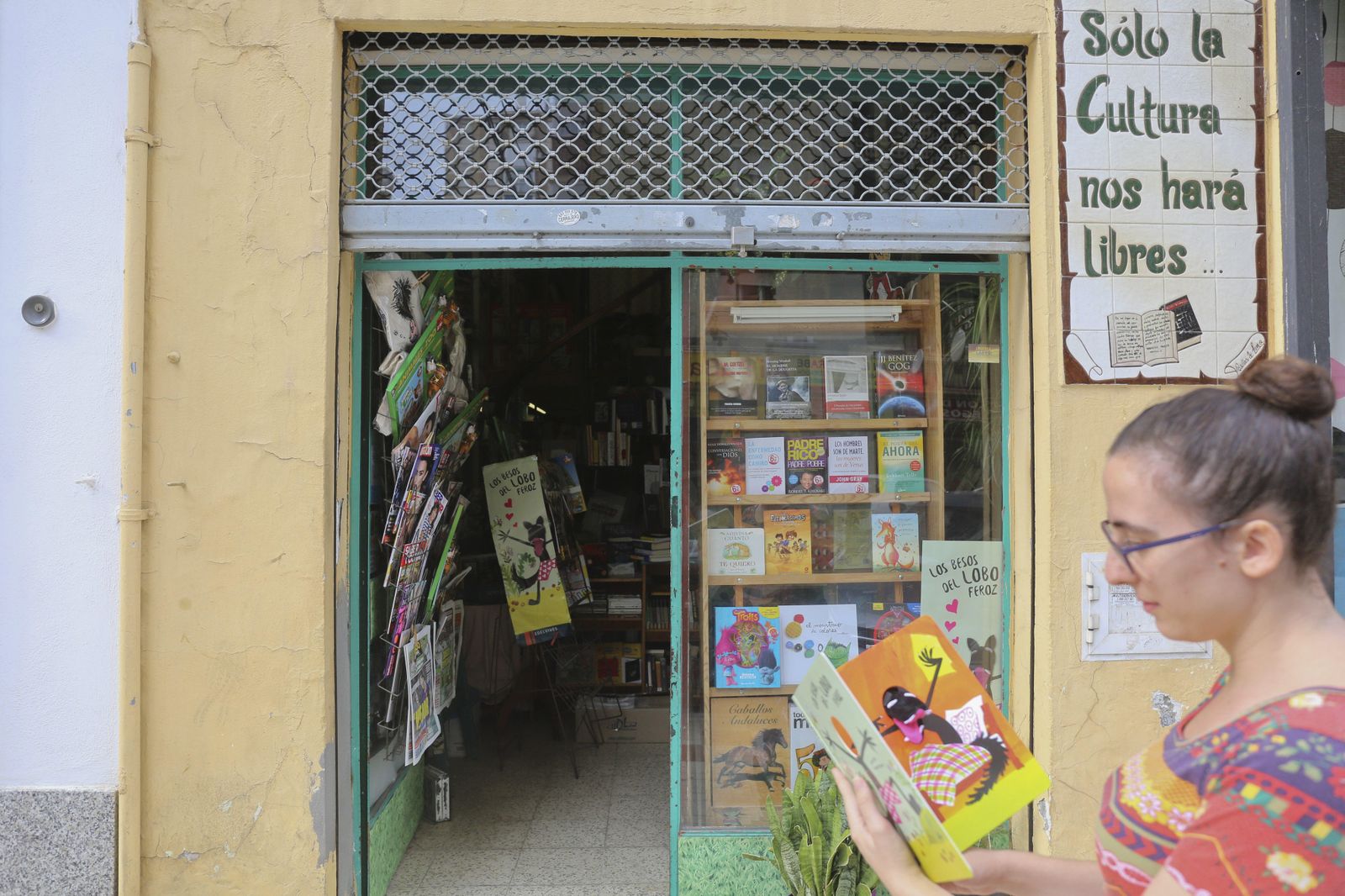 Una cliente lee un libro infantil frente a la Librería Lafer.