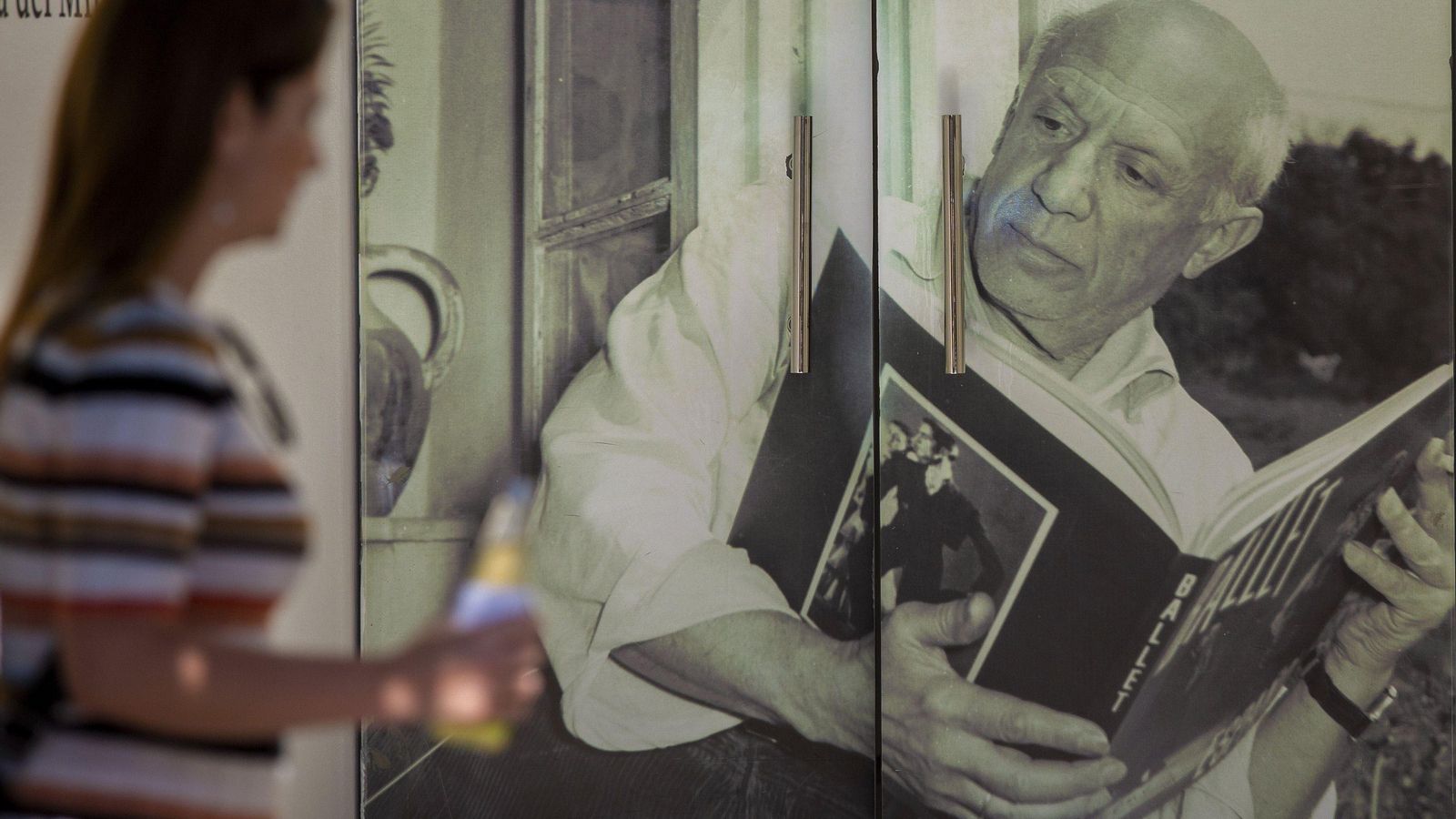 Una mujer pasa por el acceso de la Fundación Pablo Ruiz Picasso en la Plaza de la Merced de Málaga en el día del 50 aniversario del fallecimiento del pintor malagueño, este sábado.