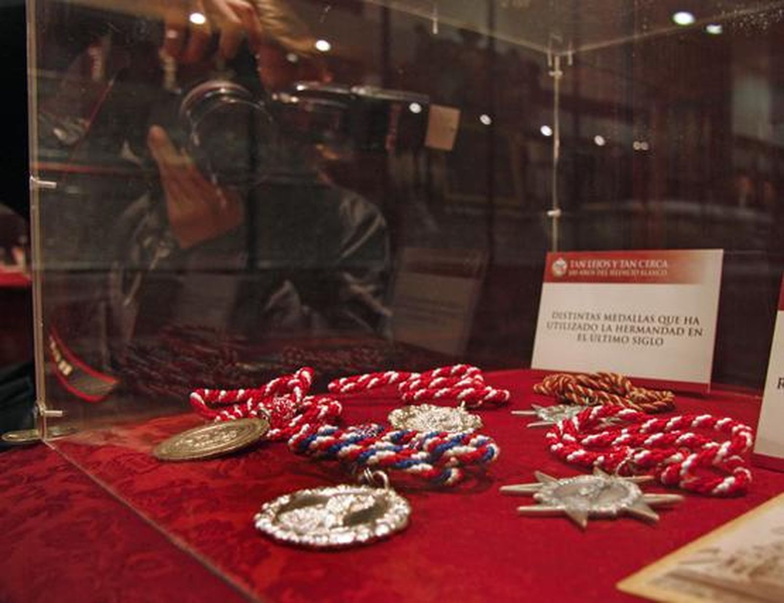 Los visitantes aprecian los objetos de la exposición "Tan lejos y tan cerca", de la Hermandad de la Amargura.

Foto: Belen Vargas