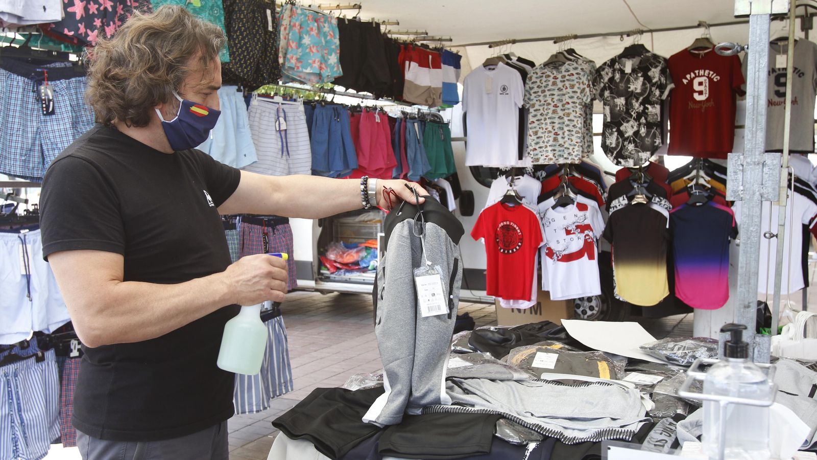 Antonio Torcuato echa desinfectante a una prenda.