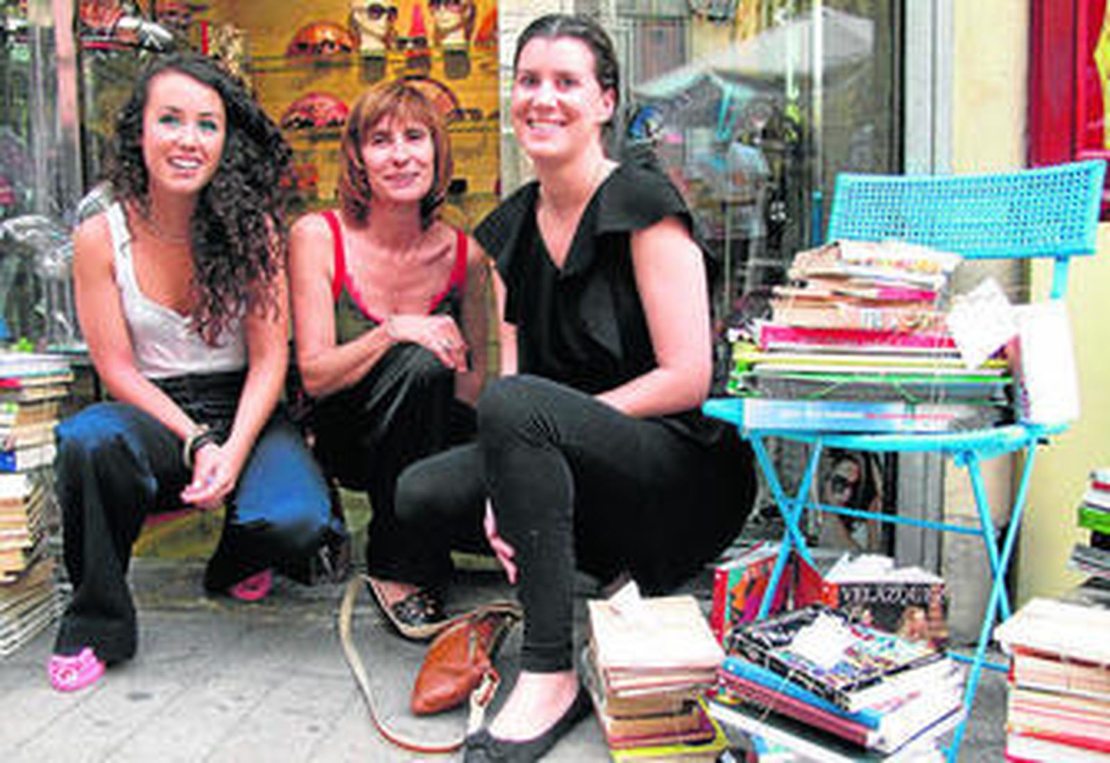 Pilar Cano, una de las comisarias de la muestra, con Mercedes Megías, propietaria de la tienda Ratones Coloraos y la artista Amelia de la Lastra, junto a la instalación de libros 'En Conserva'.