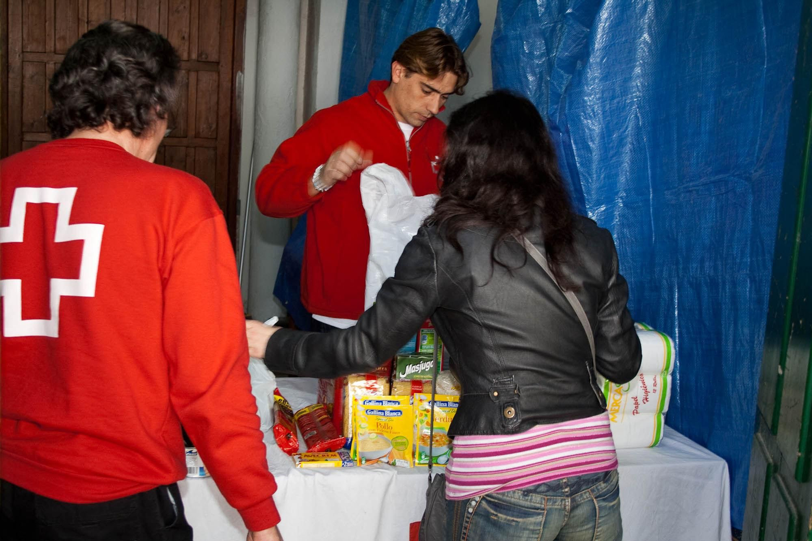 Una mujer recoge alimentos en un punto de Cruz Roja.