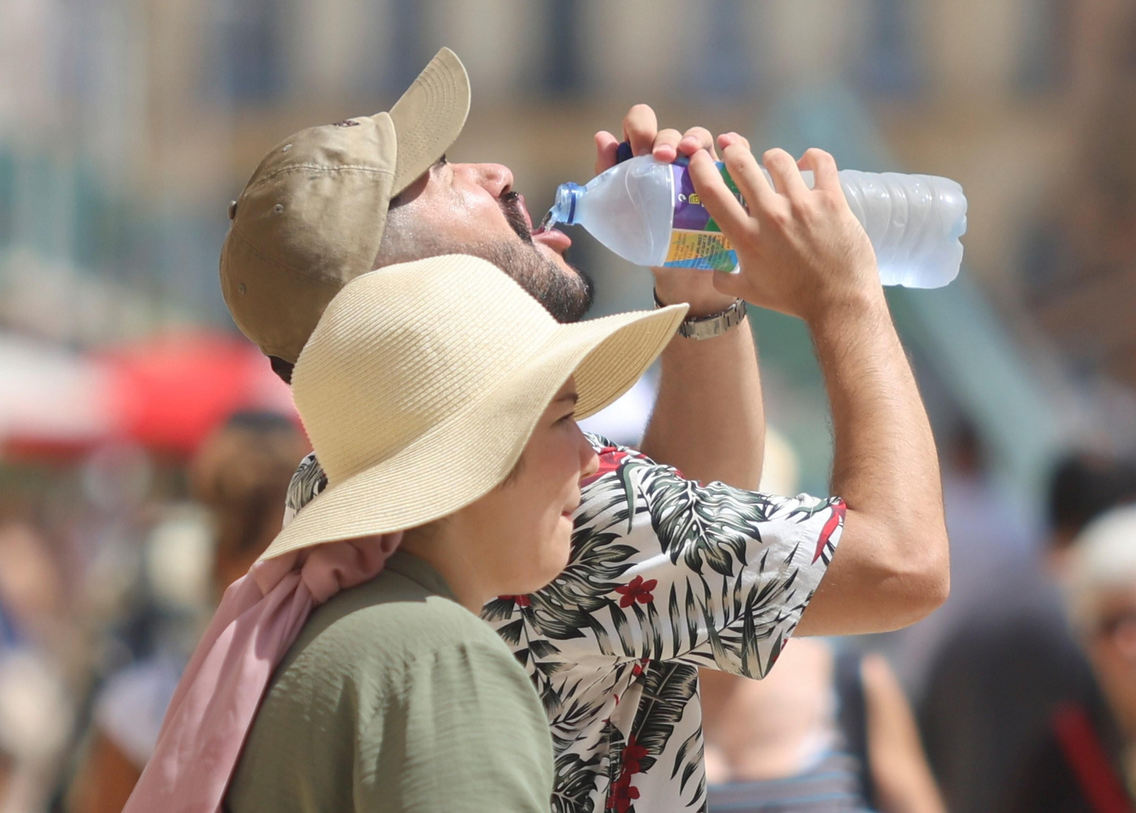 Un turista se refresca con una botella de agua en una calle de Málaga