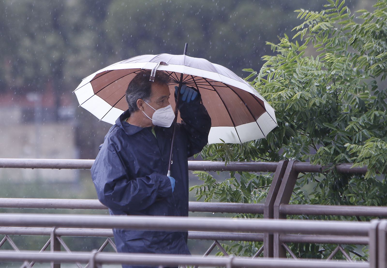 Un hombre camina con un paraguas por Sevilla