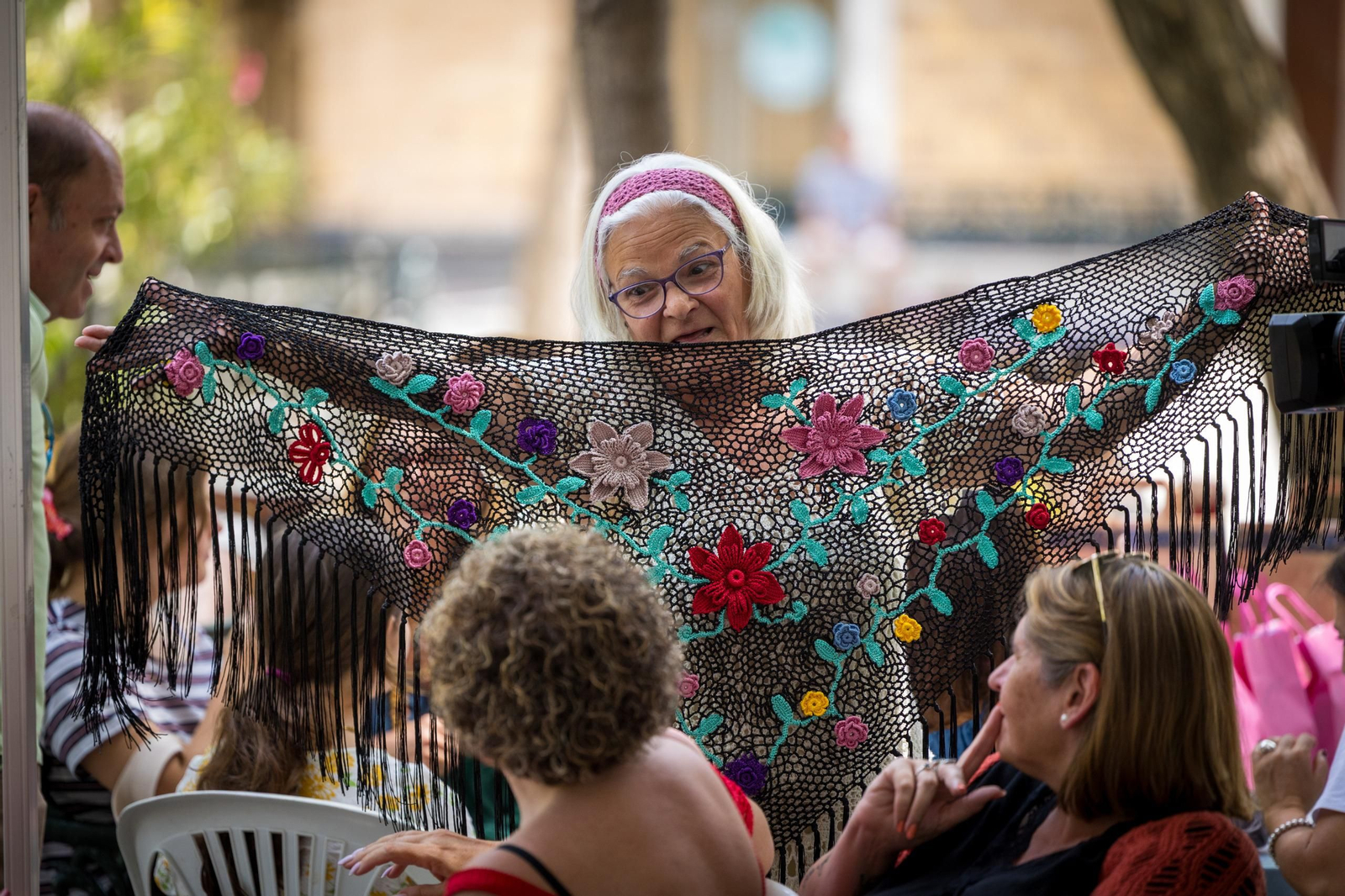 Una participante enseña un mantón confeccionado manualmente en la Plaza de Mina.