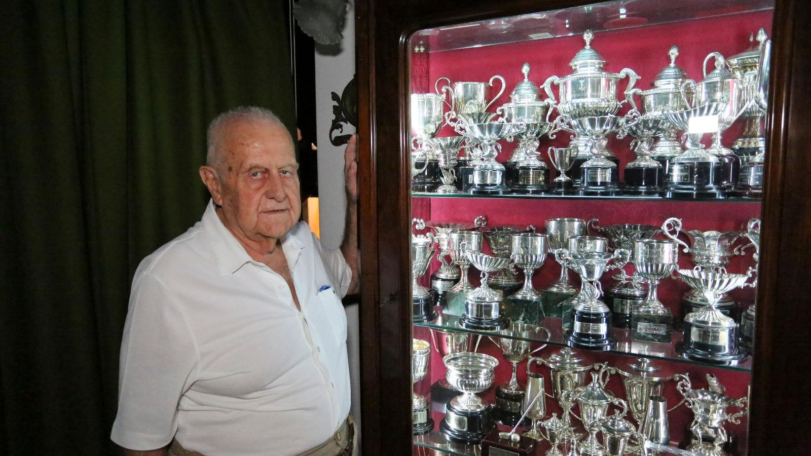 Eugenio posa junto a trofeos de vela, deporte que ha practicado hasta los 80 años.