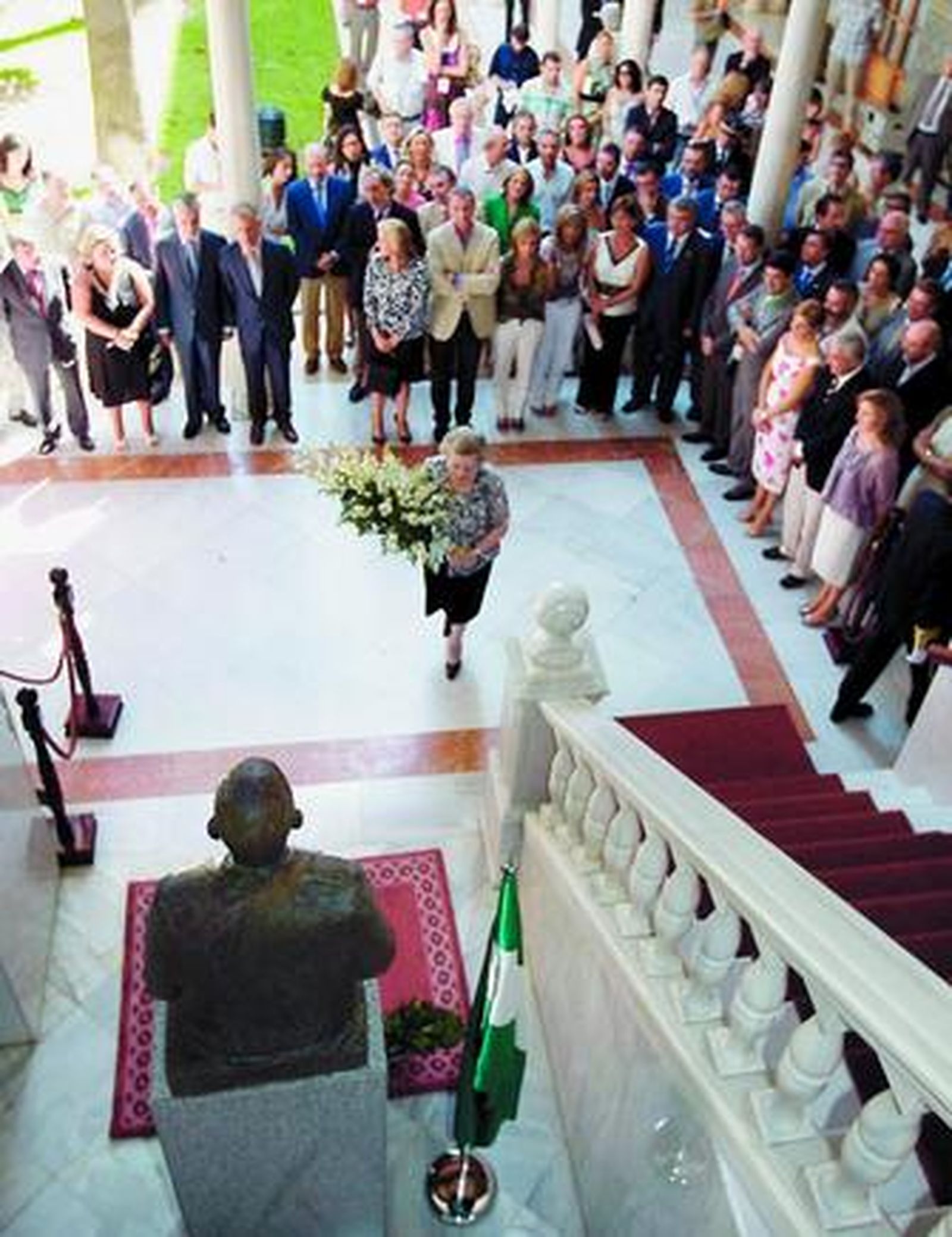 María de los Ángeles Infante deposita un ramo de flores en el busto que honra la memoria de su padre.