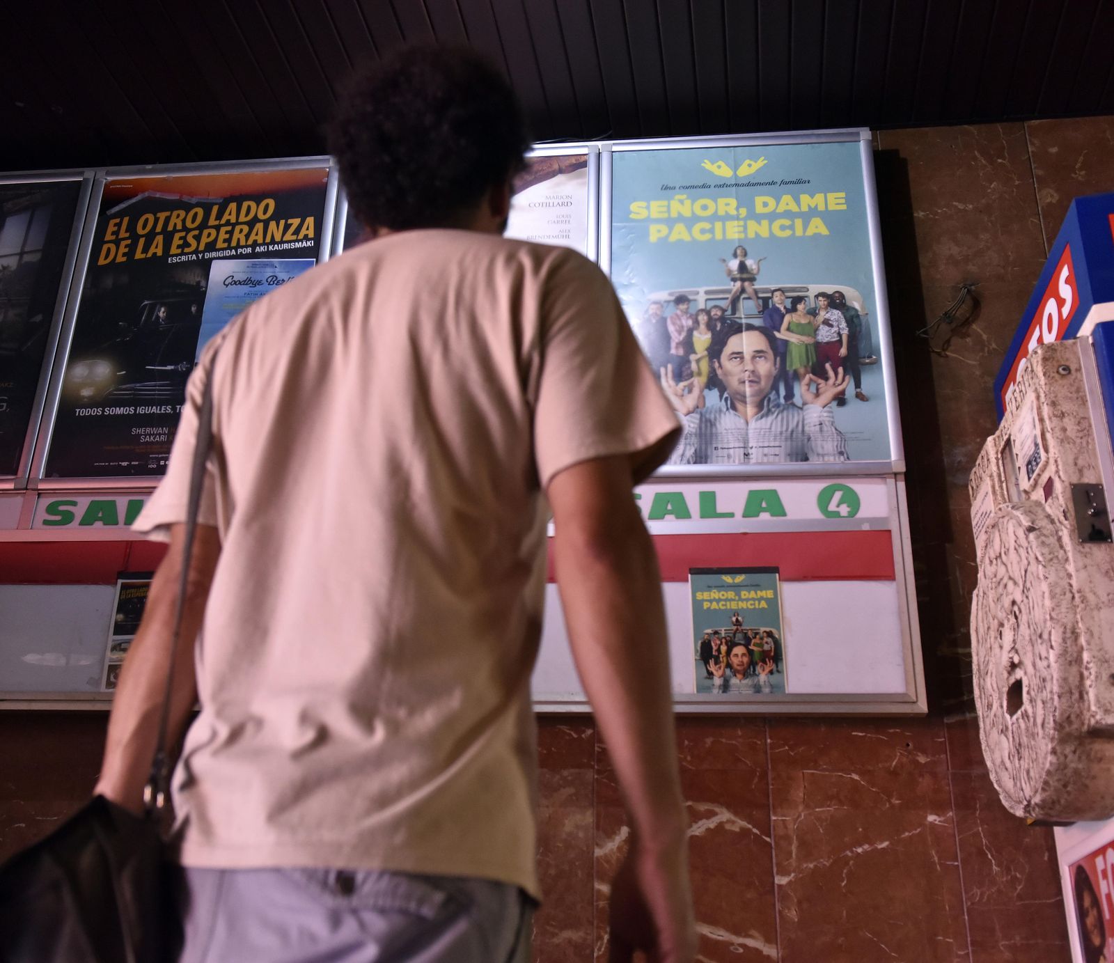 Un joven, ante el cartel de 'Señor dame paciencia', en la Alameda Multicines