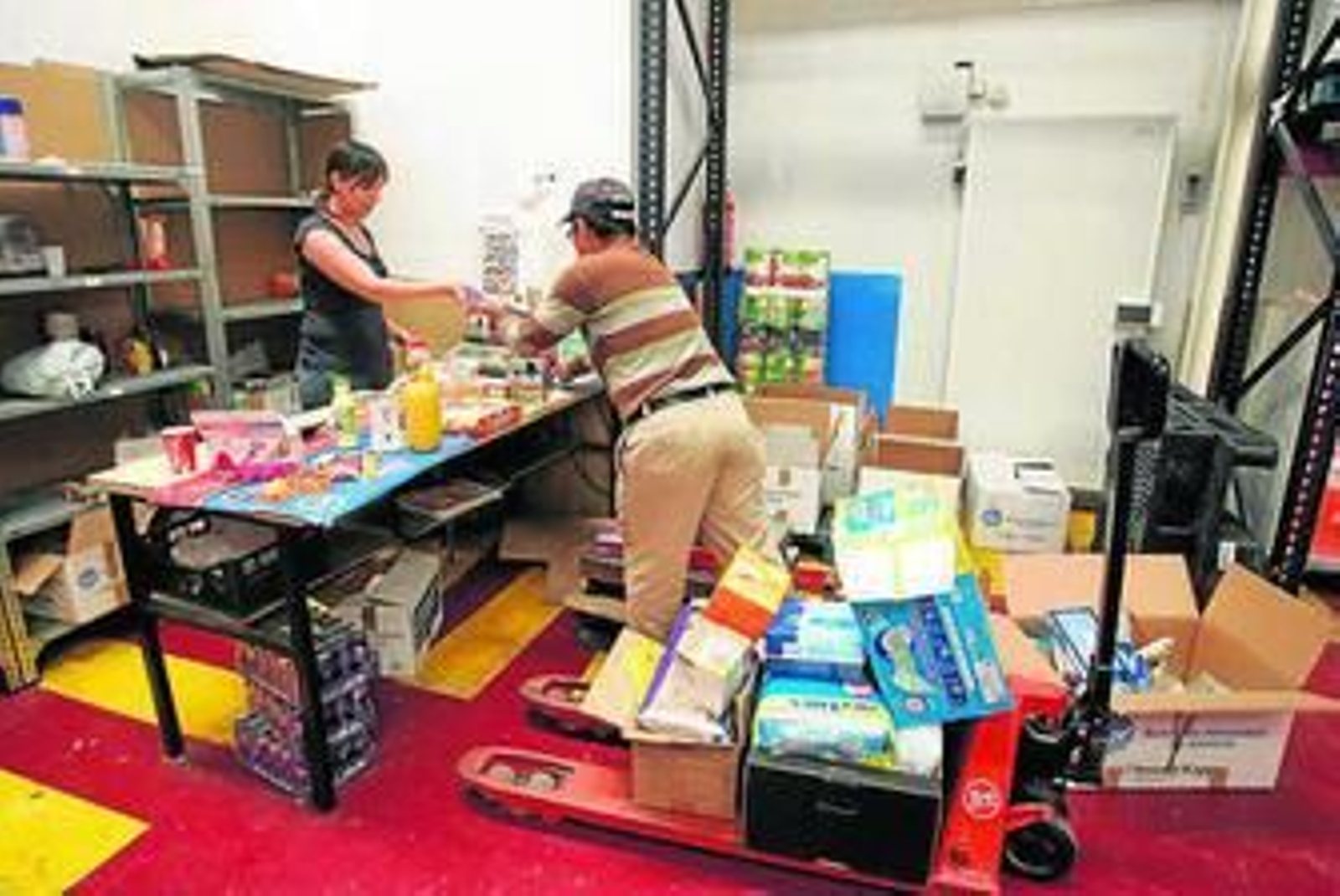 Voluntarios del Banco de Alimentos clasifican artículos no perecederos.