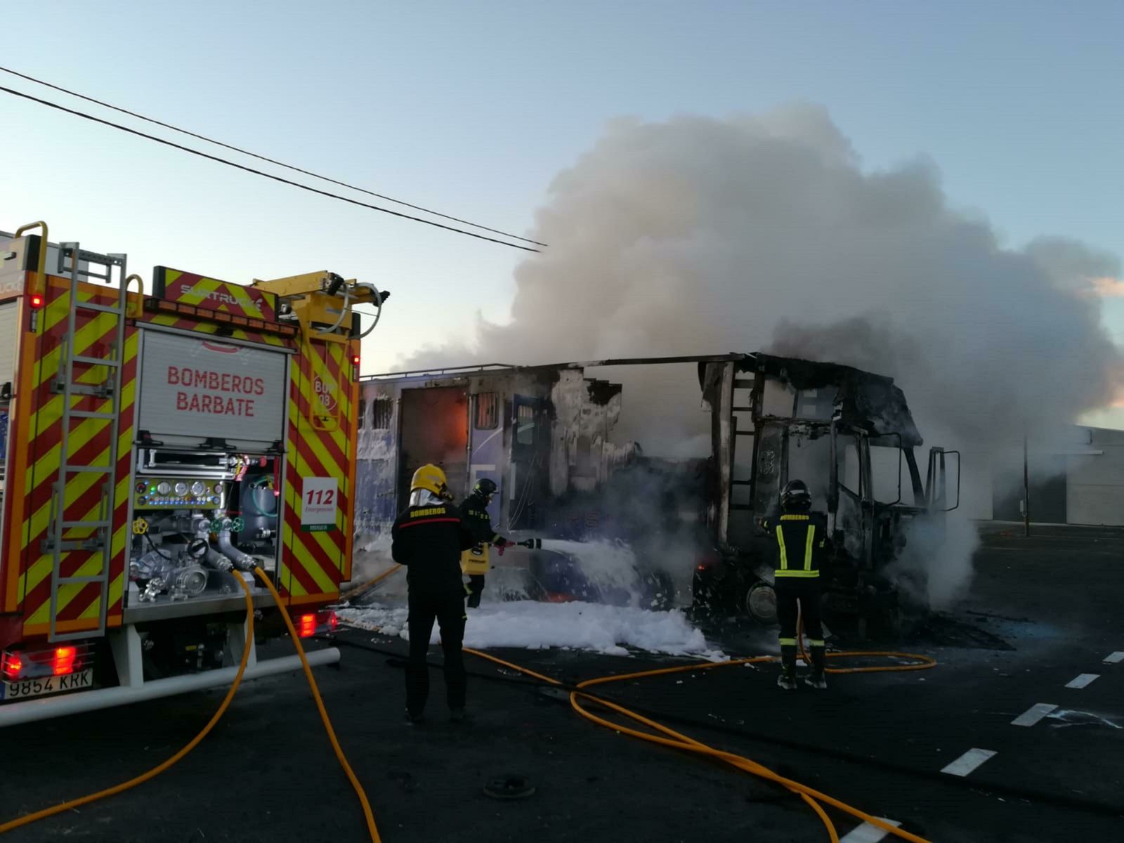 Bomberos intentando apagar el fuego en el camión.