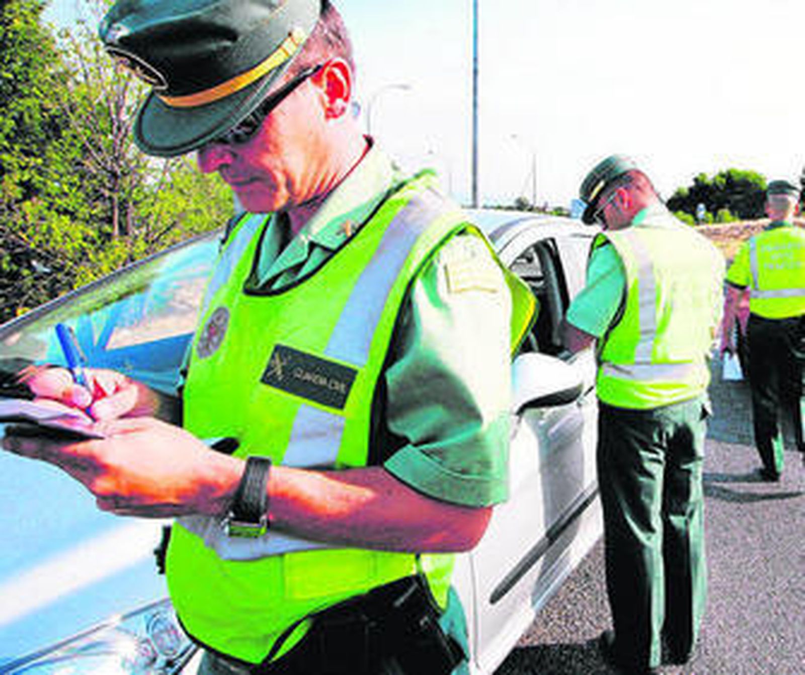 Varios agentes de la Guardia Civil de Tráfico revisan la documentación de conductores en un control.