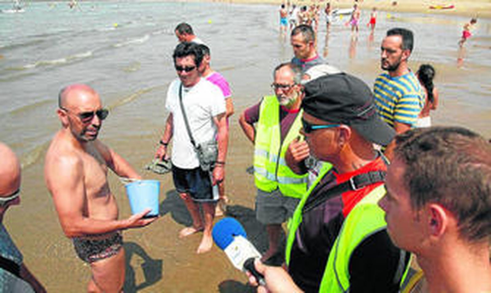 La patrulla de mariscadores informa a un bañista sobre la prohibición de coger coquinas.
