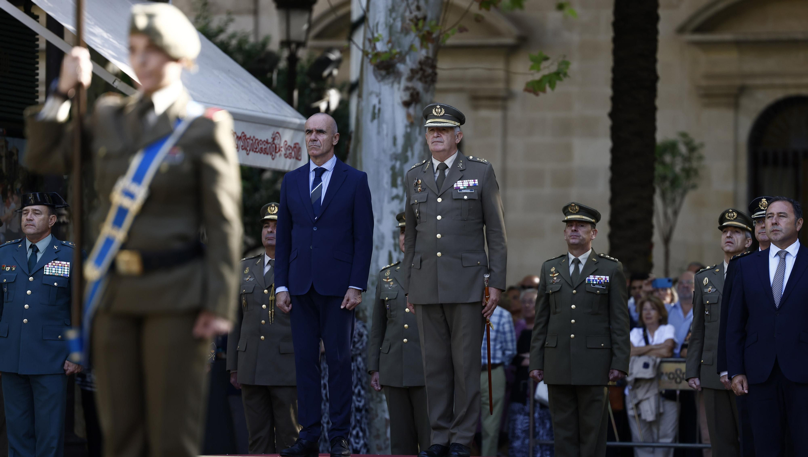 El izado de bandera y desfile militar por el centro de Sevilla, en imágenes