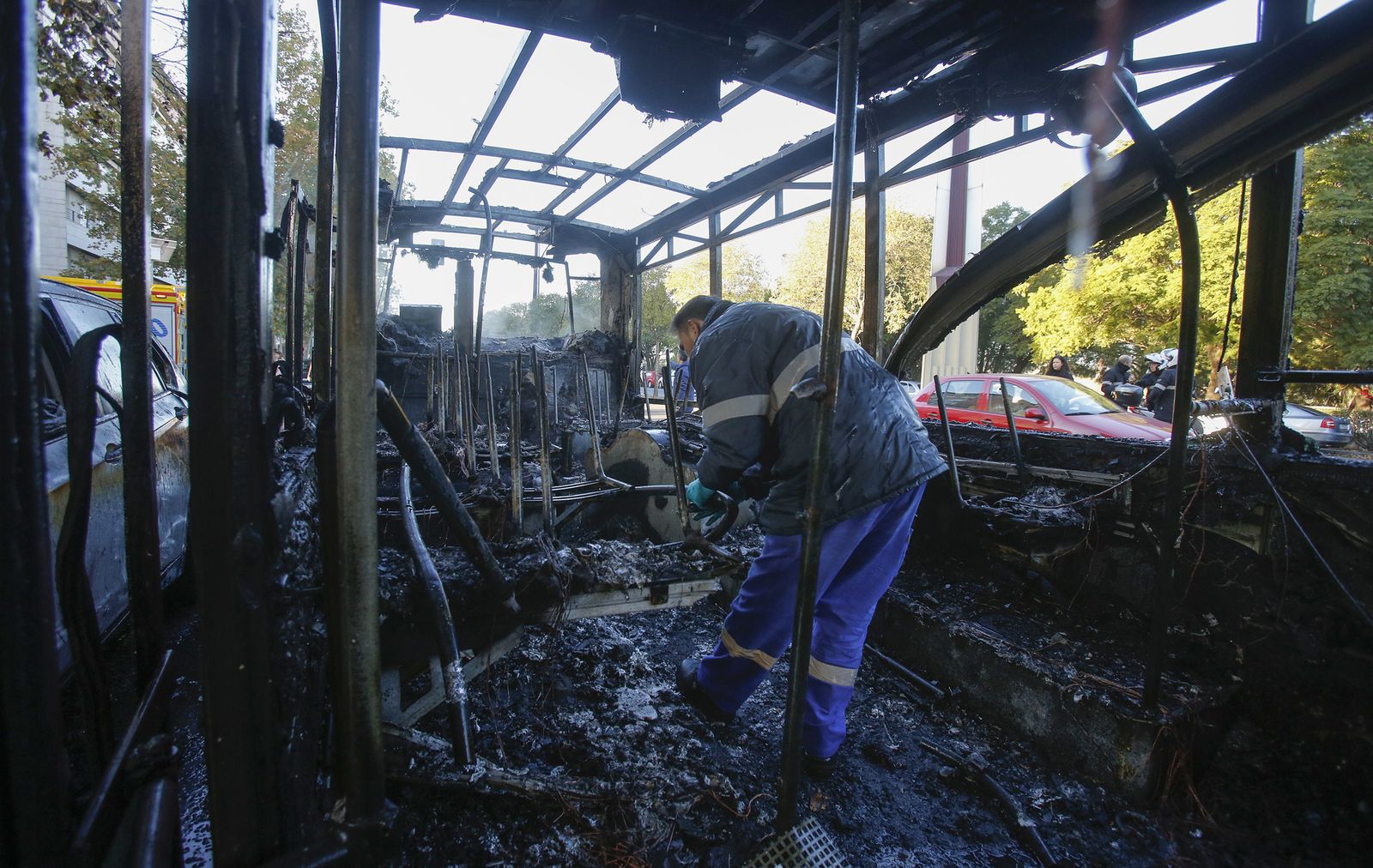 Una persona inspecciona el interior del autobús que quedó totalmente calcinado tras el incendio.