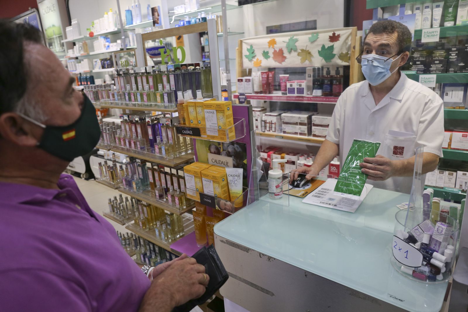 Un hombre recoge las mascarillas en una farmacia de Málaga capital.