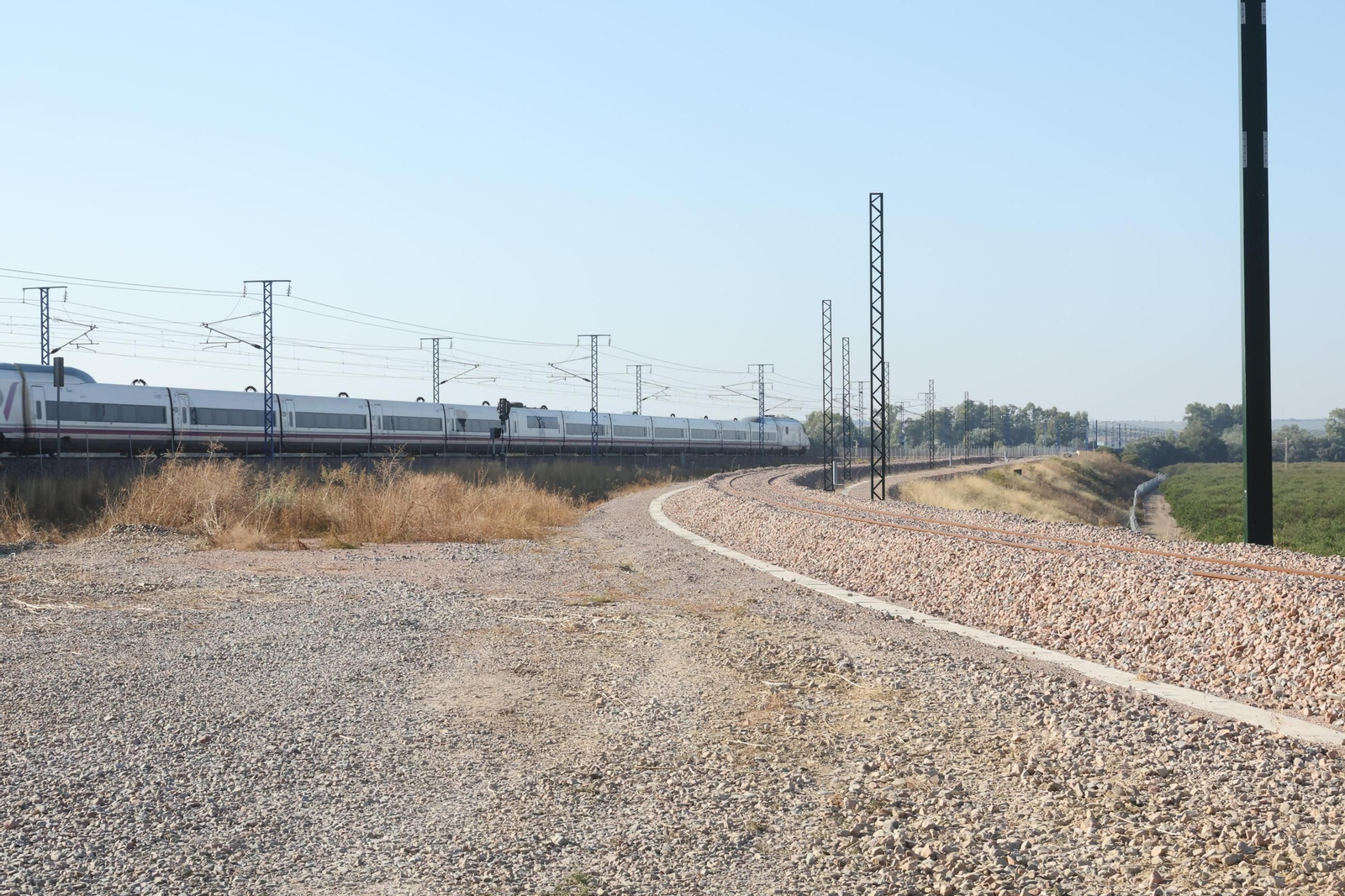 Un tren AVE circula en dirección Granada con el bypass de Almodóvar del Río premontado a su derecha en forma de curva