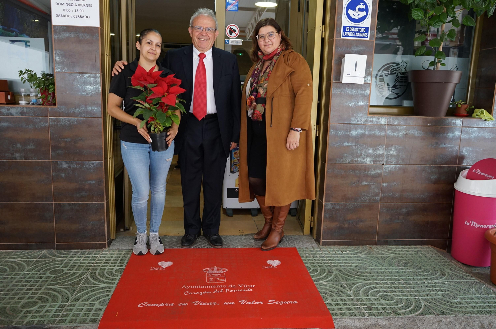 El  alcalde, Antonio Bonilla, con una comerciante con pascuero y alfombra roja