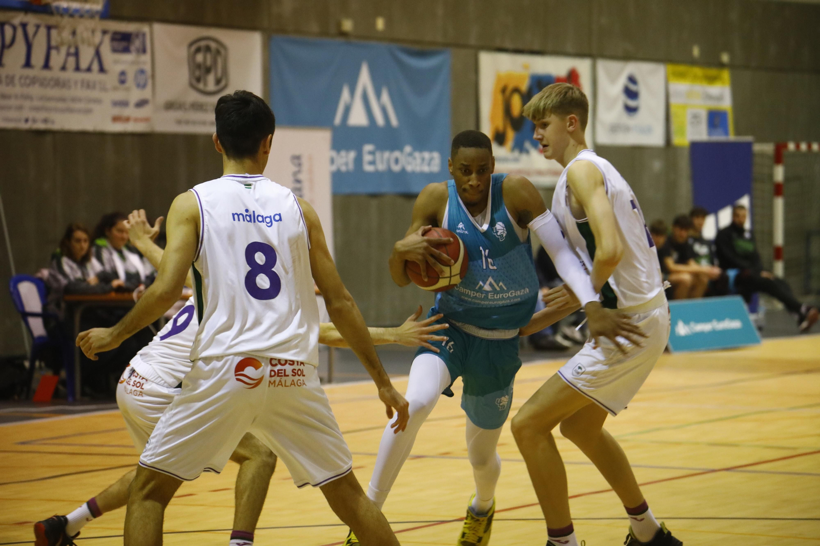 Gibson es presionado por varios jugadores del Unicaja Andalucía.