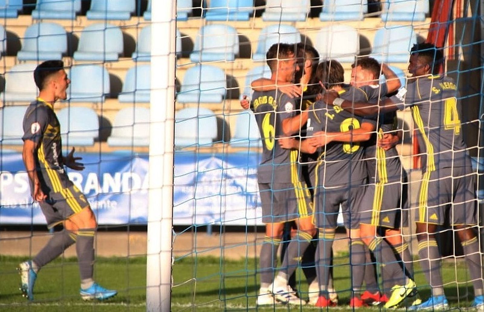 Los jugadores del filial hacen piña con Sergio Pérez, tras anotar éste el 0-1.