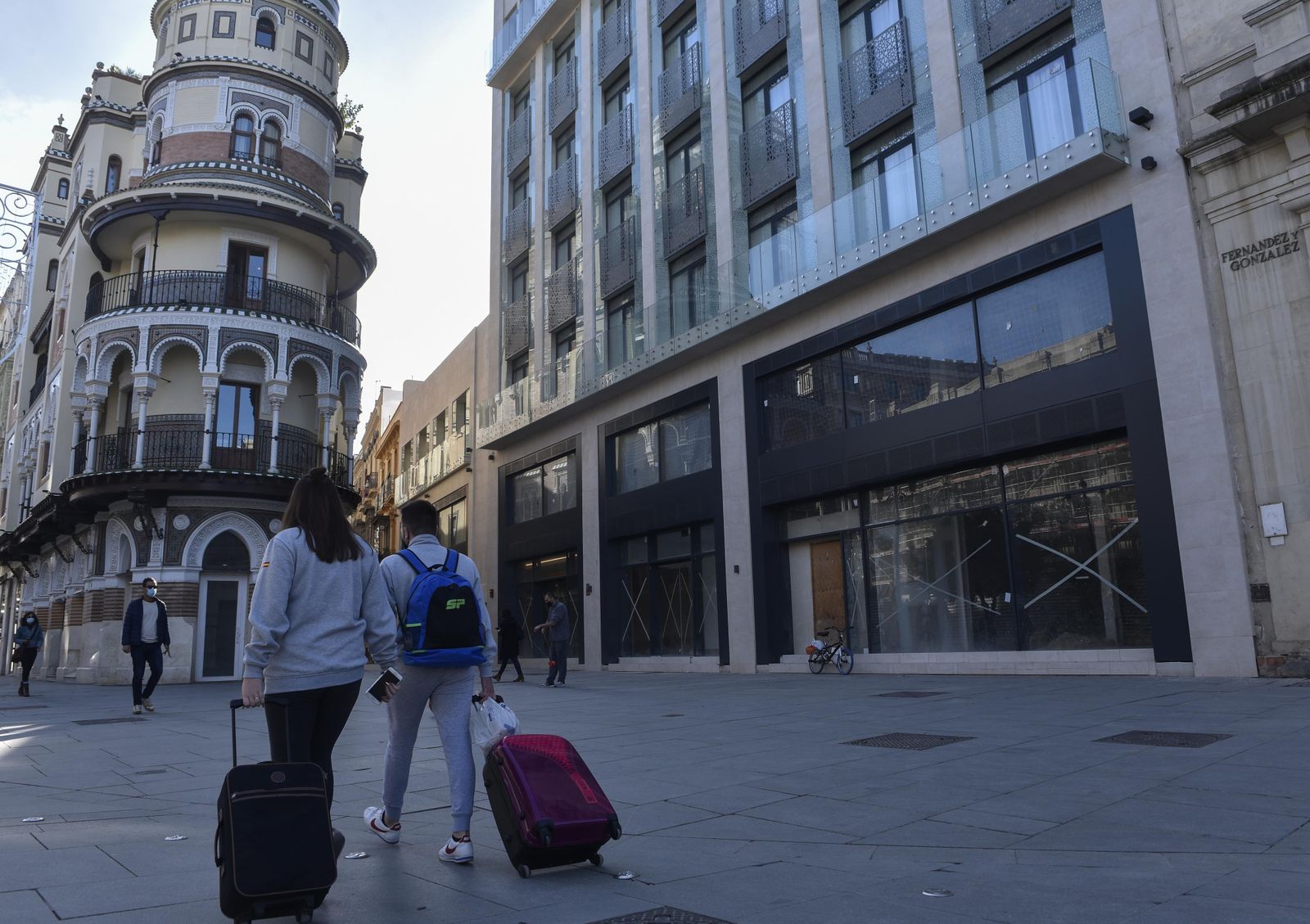 Una pareja de turistas por la Avenida de la Constitución.