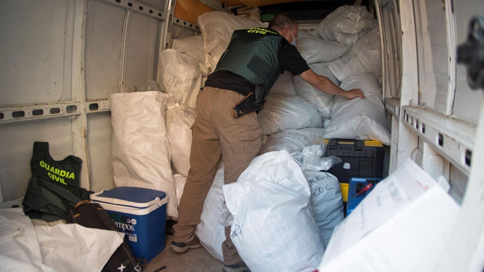 Uno de los agentes carga la marihuana intervenida para su traslado como prueba judicial.