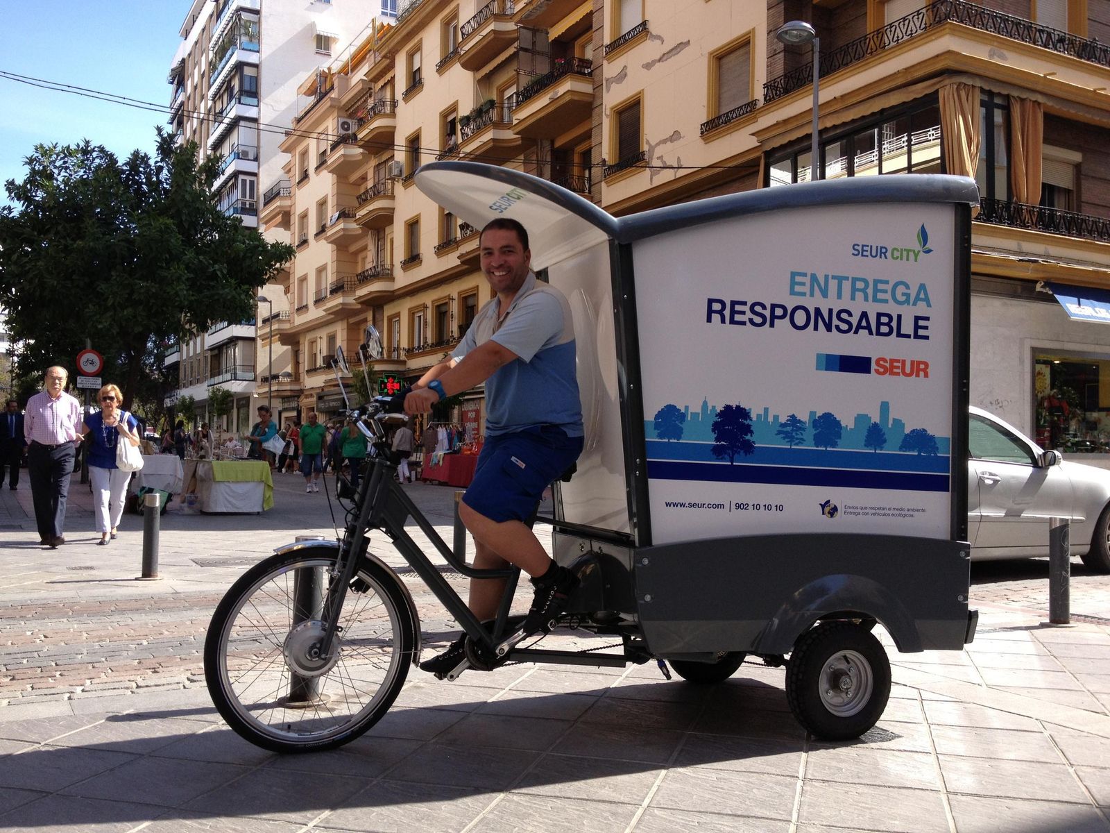 Un operario de Seur  pasa por Asunción en la bicicleta de reparto