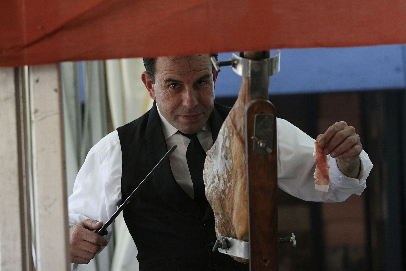 Un hombre corta jamón de la Alpujarra