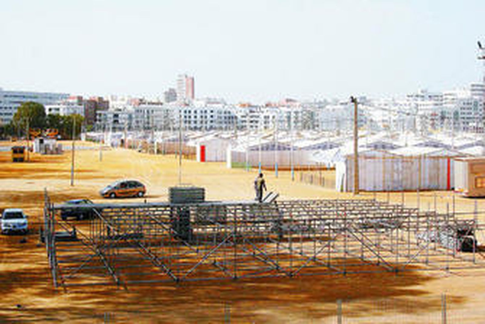 Unos operarios instalan el escenario del espacio 'Música junto a la Ría' al mismo tiempo que se van habilitando las casetas.