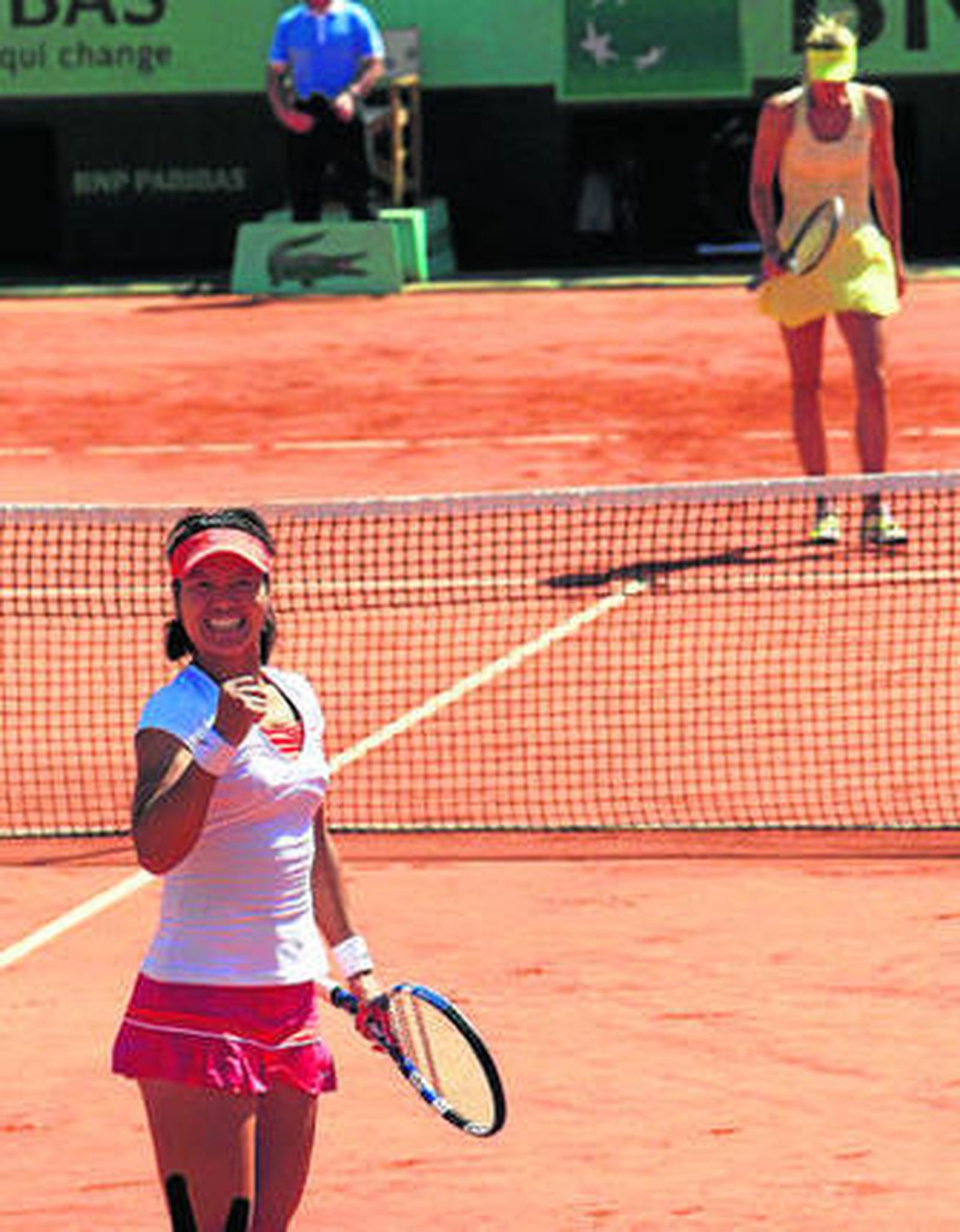 Na Li celebra su victoria mientras Sharapova camina cabizbaja hacia la red.