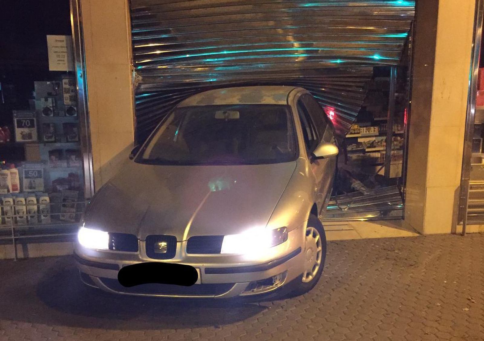 El coche empotrado contra la persiana de seguridad de la tienda de Aromas.