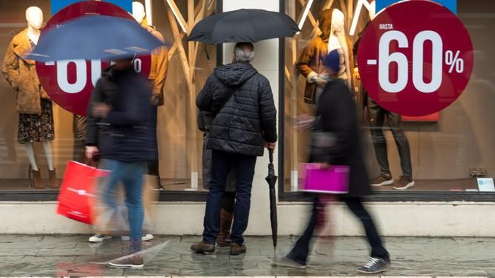 Varias personas frente a un centro comercial en Sevilla.