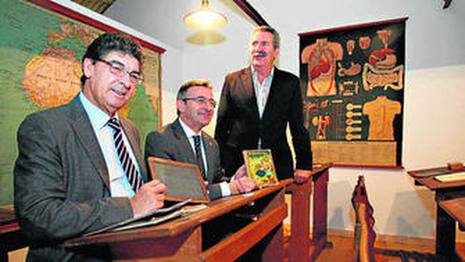 Valderas sentado en un pupitre junto al rector de la Universidad de Huelva ayer en el Museo Pedagógico de la ciudad.