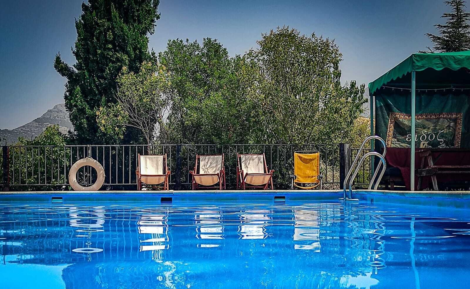 La zona de piscina está dotada de tumbonas y una zona de sombra con sofás y mesa.