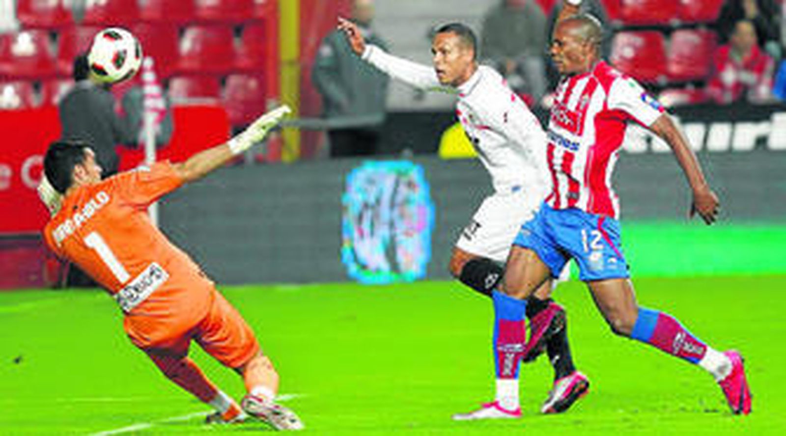 El delantero sevillista Luis Fabiano trata de superar por alto a Juan Pablo en presencia del defensa Gregory.