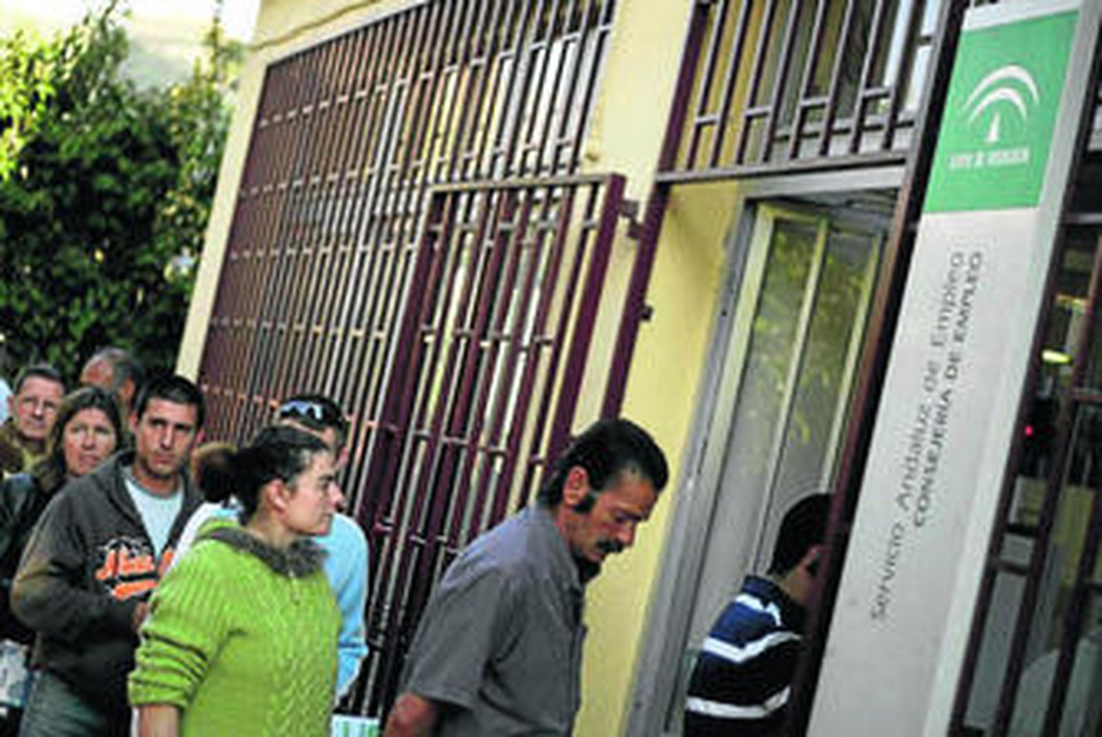 Varias personas hacen cola en una oficina del Servicio Andaluz de Empleo.