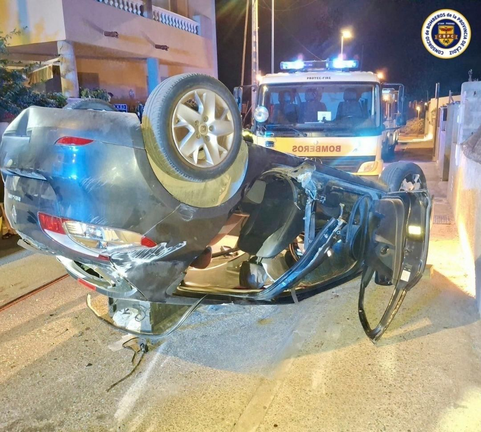 El turismo que tuvo el accidente de tráfico en Sanlúcar, volcado sobre la calzada.